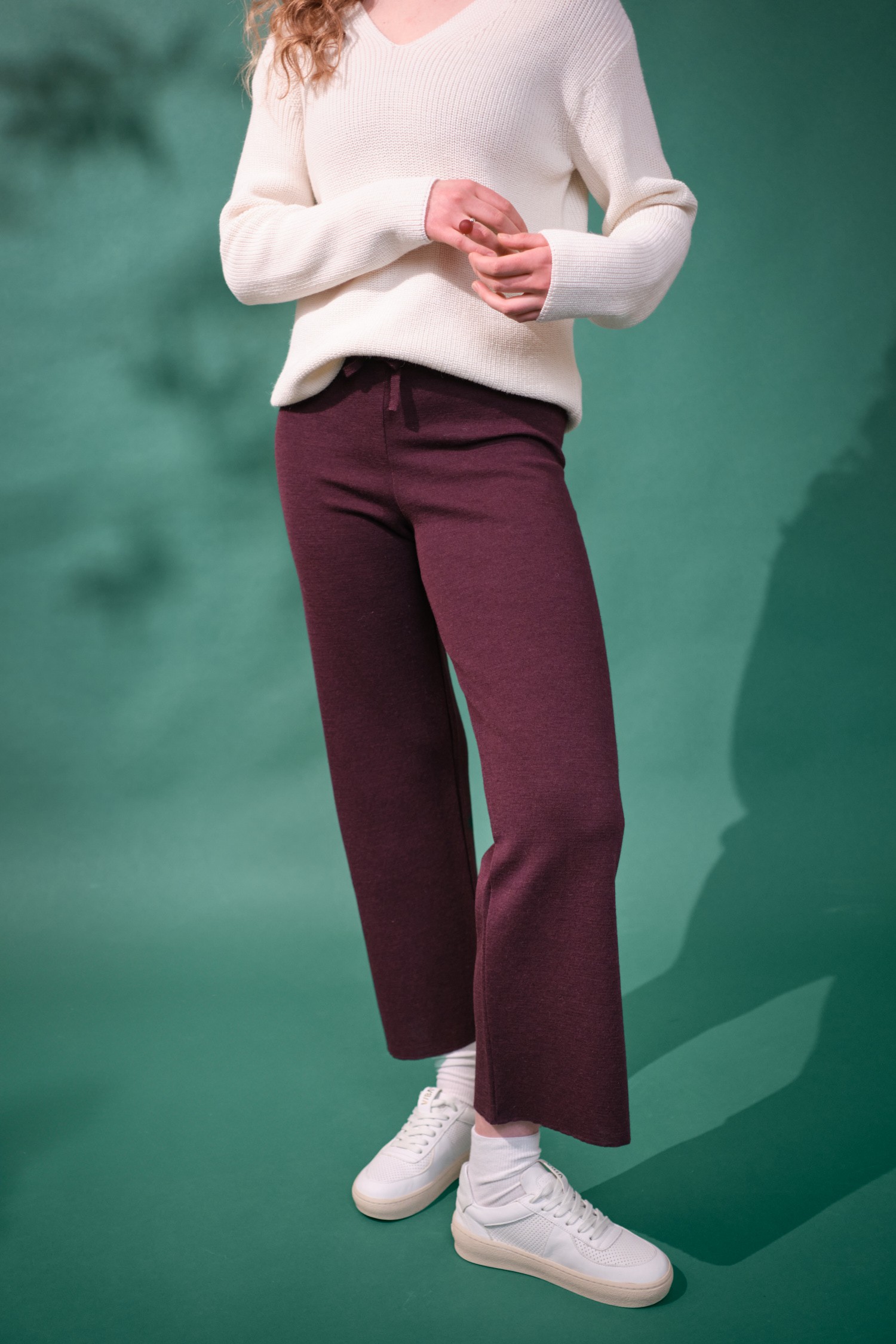 Viikunanväriset housut, jotka on valmistettu alpakanvillasta. Kuvassa mallin päällä vihreää taustaa vasten.