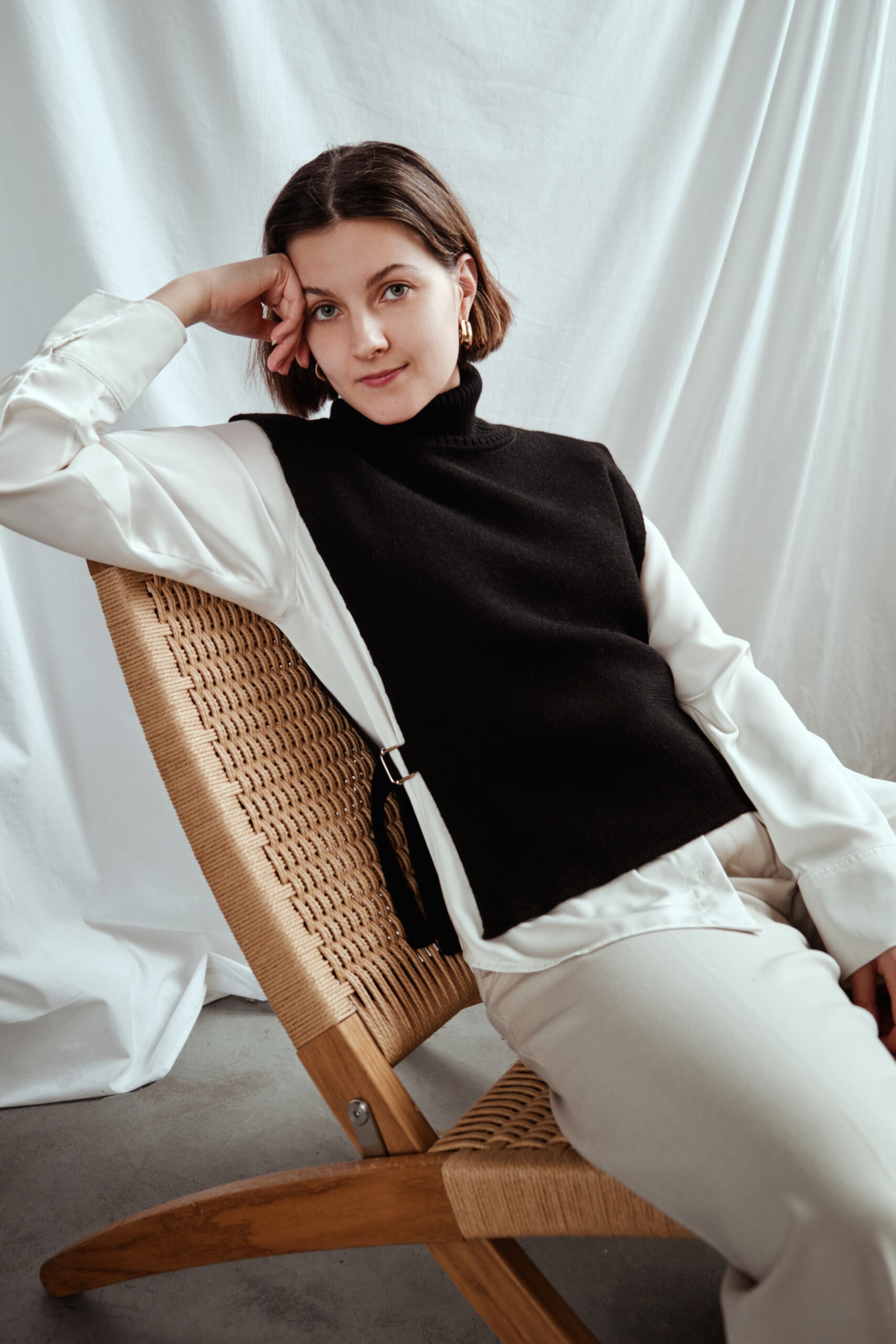 Kuvassa nainen, jolla yllään musta neuleliivi muhkealla poolokauluksella.